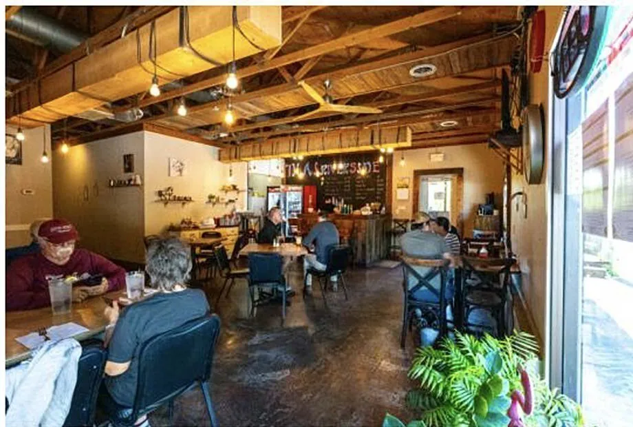 Restaurant dining area with exposed wood ceilings and bar